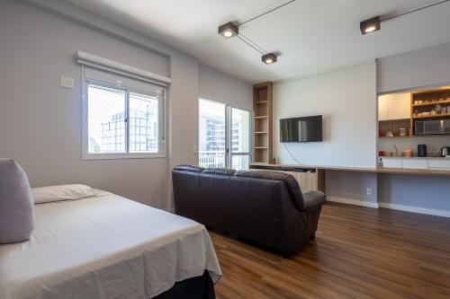 een kamer met een bed, een bank en een keuken bij Alto padrão 2 dorms vista para Piscina até 6 pessoas in Sao Paulo