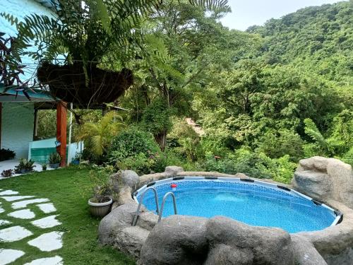 uma piscina com pedras à volta num quintal em CasaLuna Tayrona em Santa Marta