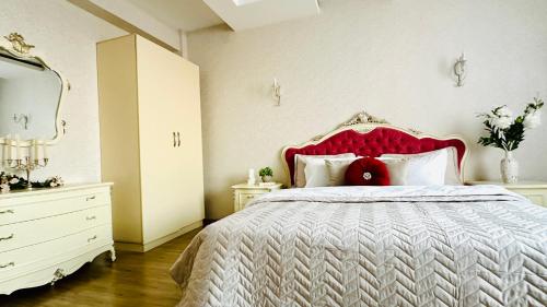 a bedroom with a large bed with a red headboard at Бухар Жырау Ботанический in Almaty