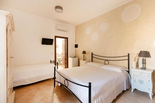 a bedroom with two beds and a tv on the wall at Palazzo De Luca by Apulia Hospitality in Fasano