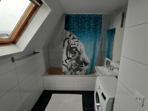 a bathroom with a tiger shower curtain and a sink at Butthouse Apartments in Trimbach