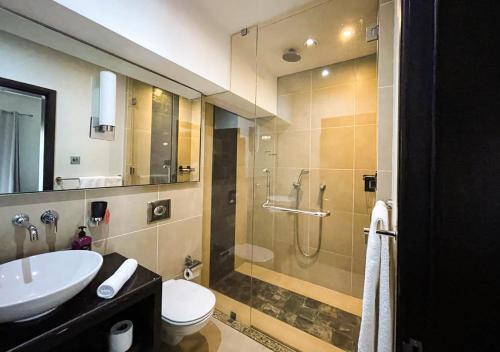 a bathroom with a shower and a sink and a toilet at Private Beach 5-star Villa, Golf & Luxe in Centre de Flacq