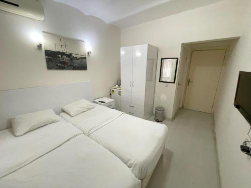 a white bedroom with a bed and a tv at Eagle Residence Taksim in Istanbul