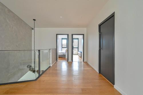 ein leerer Flur mit einer Glastür und einem Zimmer in der Unterkunft L'Eve - Maison pour 12 personnes - Ping-Pong in Le Perreux-sur-Marne