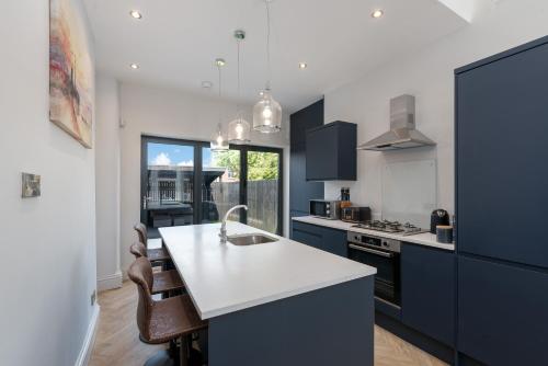 a kitchen with blue cabinets and a white counter top at Bifolds, enclosed garden. Southport character home in Southport