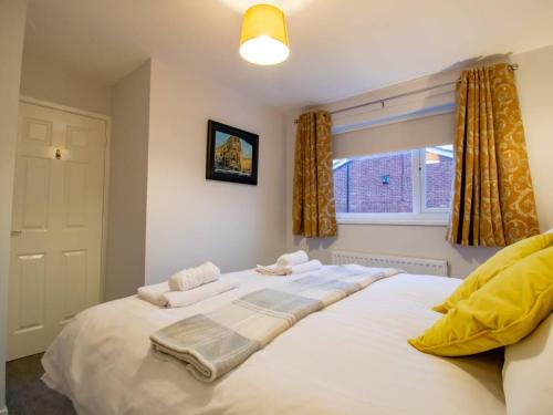 een slaapkamer met een groot wit bed en een raam bij Pass the Keys Fantastic Coastal House in Tynemouth
