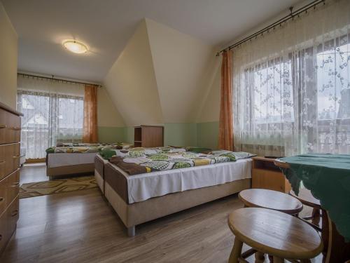 a bedroom with two beds and a table and chairs at U KOMINKA in Zakopane