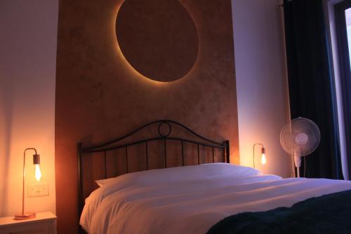 ein Schlafzimmer mit einem großen Bett mit einem Mond an der Wand in der Unterkunft Door 51 in St Julian's