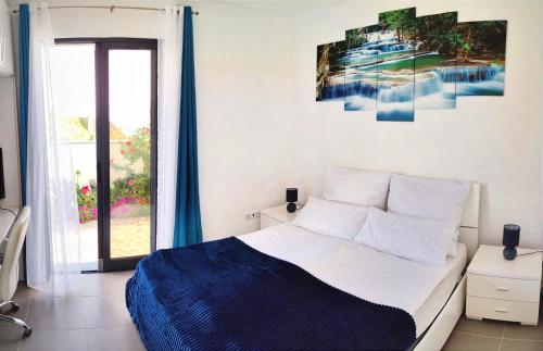 - une chambre avec un lit et une grande fenêtre dans l'établissement Casa Panorama Sol, à Ponta do Sol