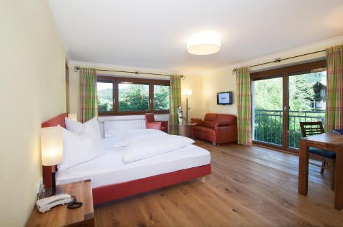 a bedroom with a large white bed and a desk at Hotel Landgasthof Gappen in Kramsach