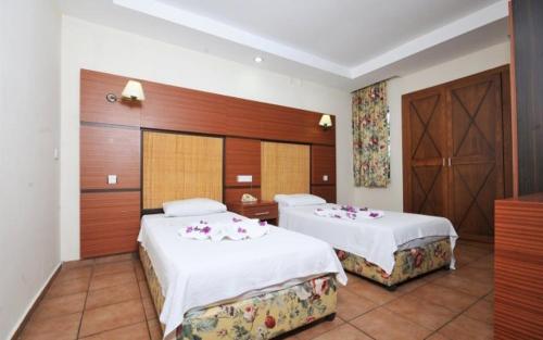 a hotel room with two beds with flowers on them at GREENPARK APARTMENTS in Marmaris