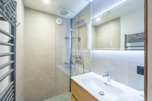 a bathroom with a sink and a glass shower at Chalet L'arcelle, Spa privée in Lanslebourg-Mont-Cenis