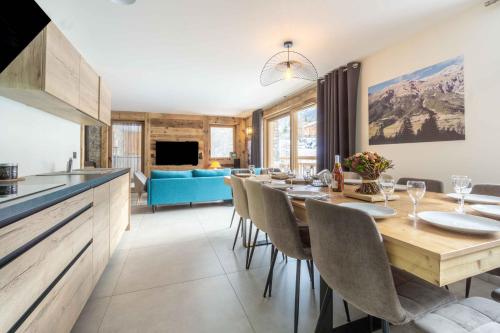 une cuisine et une salle à manger avec une table et des chaises dans l'établissement Chalet L'arcelle, Spa privée, à Lanslebourg-Mont-Cenis