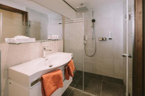a bathroom with a sink and a shower at Hotel Montana in Obertauern