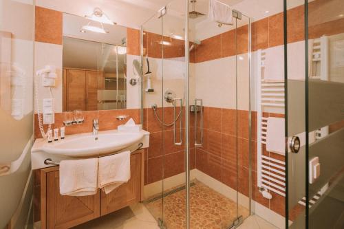 a bathroom with a sink and a shower at Hotel Montana in Obertauern