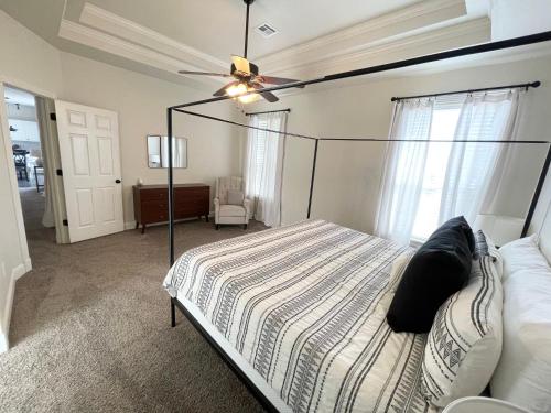 - une chambre avec un lit et un ventilateur de plafond dans l'établissement Bike in Bike out Coler The Trail House, à Bentonville