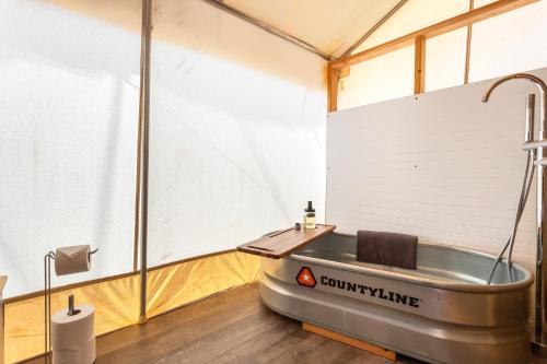 a tub in a tent with a sink in it at Silver Spur Homestead Luxury Glamping -The Tombstone in Tombstone