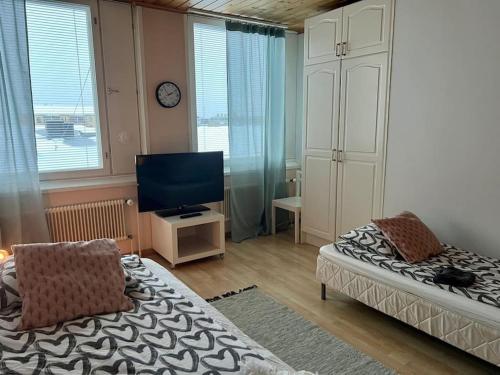 a bedroom with a bed and a tv and a chair at Apartment Isokatu2 in Kokkola