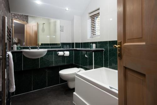 a bathroom with a toilet and a sink and a tub at Windermere Rooms at The Wateredge Inn in Ambleside