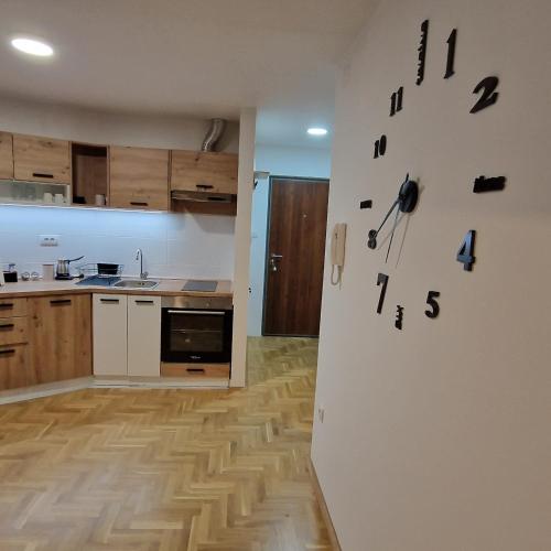 a kitchen with a clock on the wall at Stan na dan Apartman S in Požarevac