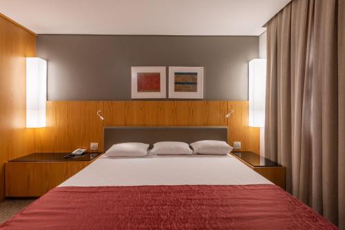 a bedroom with a large bed with two night stands at DELPLAZA Marabá São Paulo in Sao Paulo