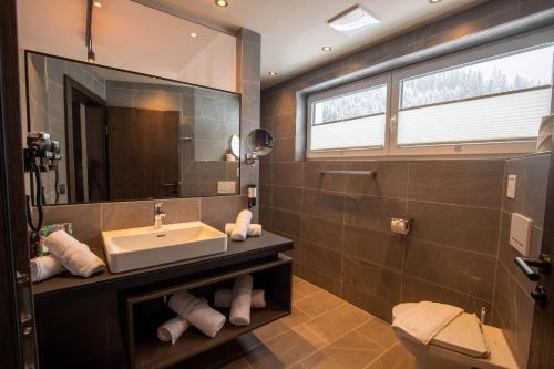 W łazience znajduje się umywalka i lustro. w obiekcie Place2be w mieście Ischgl