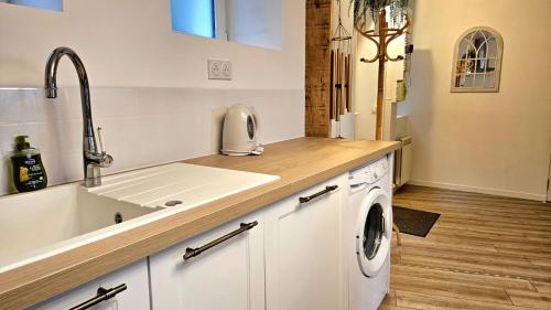 une cuisine avec un évier et une machine à laver dans l'établissement Appartement neuf en centre ville, à Trouville-sur-Mer