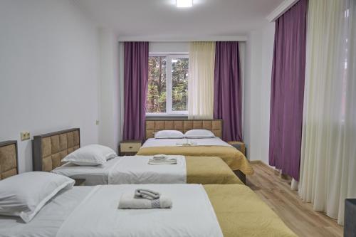 a hotel room with two beds and a window at Hotel Lile • სასტუმრო ლილე in Khulo