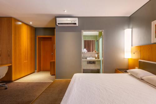 a hotel room with a bed and a bathroom at DELPLAZA Marabá São Paulo in Sao Paulo