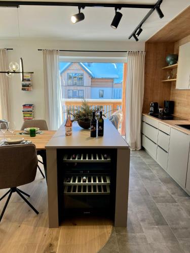 a kitchen with a island with a wine cellar at Das Genner - Boutique Appartement in Tauplitz