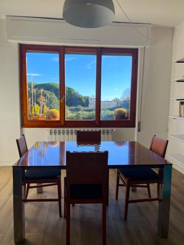 a dining room table with chairs and a large window at -Secret View - Marina di Carrara in Carrara