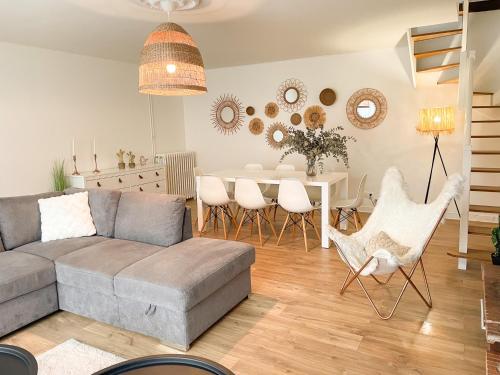 ein Wohnzimmer mit einem Sofa und einem Tisch in der Unterkunft Maison spacieuse et chaleureuse in Condé-sur-Sarthe
