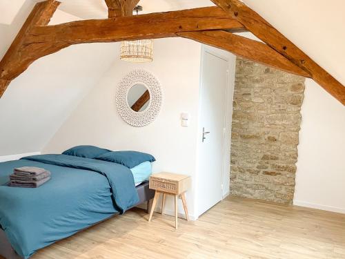ein Schlafzimmer mit einem blauen Bett und einer Steinmauer in der Unterkunft Maison spacieuse et chaleureuse in Condé-sur-Sarthe