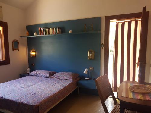a bedroom with a bed and a blue wall at Villa Marilena - Goelba in Fetovaia