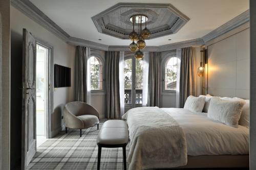 ein Schlafzimmer mit einem großen Bett und einem Stuhl in der Unterkunft Les 2 chalets - Les appartements du Strato in Courchevel