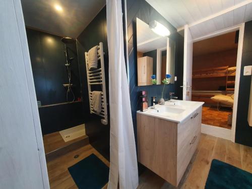 La salle de bains est pourvue d'un lavabo blanc et d'une douche. dans l'établissement Chalet ALOA, à Le Bonhomme