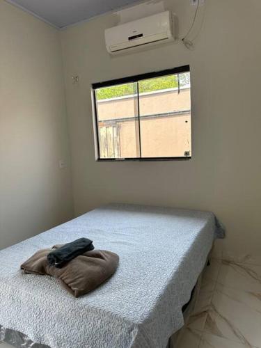 uma cama num quarto com uma almofada em Casa Davisis - Parada Jalapão e Próximo Aeroporto em Palmas
