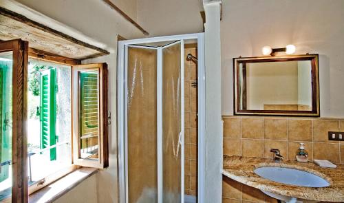 baño con lavabo, espejo y ventana en Terra Di Michelangelo, en Caprese Michelangelo