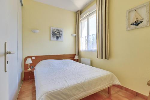 une chambre avec un lit et une fenêtre dans l'établissement 400m de la plage, appartement avec piscine, à Saint-Jean-de-Monts