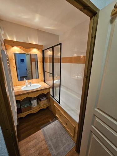 une salle de bain avec un lavabo, une douche et un miroir dans l'établissement Les 3 Vallées - Hameau des eaux d'Orelle - Appartement 003, à Orelle