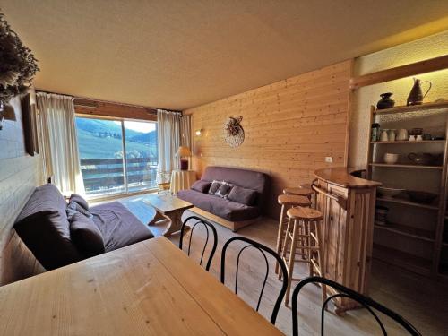 un salon avec un canapé et une table dans l'établissement Aiguille Verte 27 - Studio avec vue, à La Clusaz