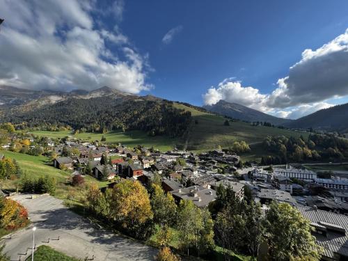 une petite ville dans une vallée avec une montagne dans l'établissement Aiguille Verte 27 - Studio avec vue, à La Clusaz