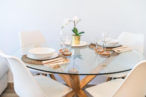 a glass dining room table with white chairs at Magec Santa Cruz in Santa Cruz de Tenerife