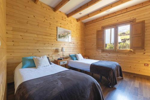 two beds in a room with wooden walls at Villa Montaña Ilusión Parking wifi Bbk y Vistas in La Orotava