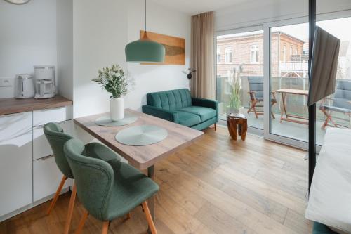 a kitchen and living room with a table and chairs at Haus Noena - Wohnung 7 Inselschatz in Norderney