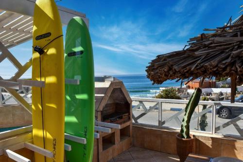 two surfboards are standing on a balcony with the beach at Cactus pool House - Luxe - 6 Px in Imsouane