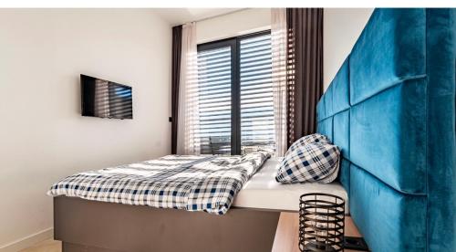 Schlafzimmer mit einem Bett und einem Fenster in der Unterkunft Penthouse Apartment Bulevar Sarajevo in Sarajevo