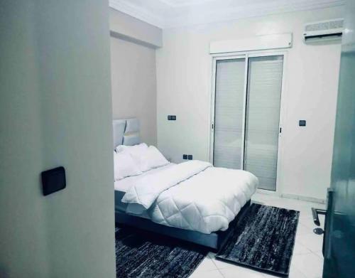Habitación blanca con cama y ventana en the best appartement en Taza