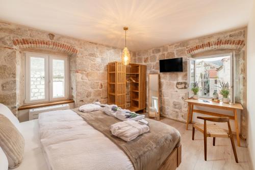 a bedroom with a large bed and a desk at Villa Rita Heritage Villas in Kaštela