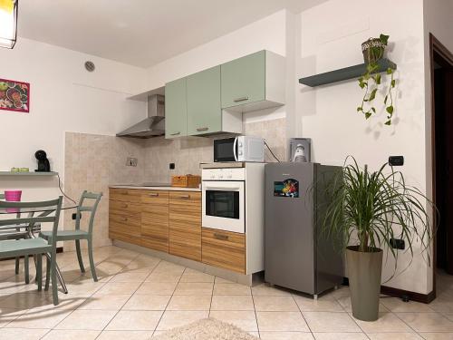 a kitchen with a stainless steel refrigerator and a table at Aliss Home ASSISI in Bastia Umbra